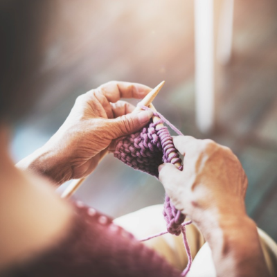 Woman knitting with purple fabric